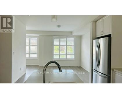 A kitchen with a stainless steel refrigerator and a sink.