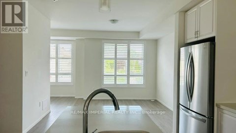 A kitchen with a stainless steel refrigerator and a sink.