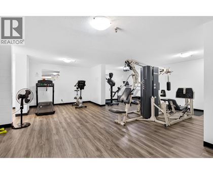 A gym with a variety of equipment including a treadmill, weights, and a bench press.