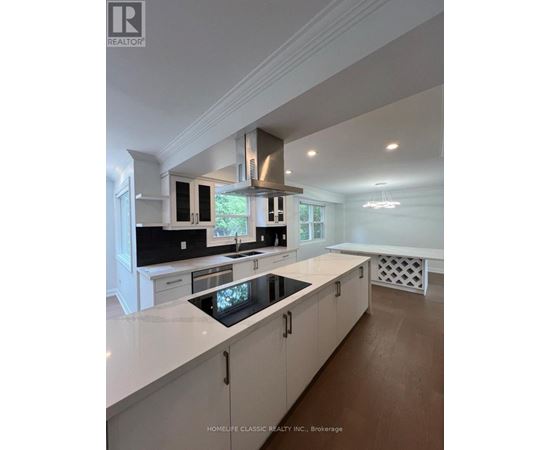A modern kitchen with white cabinets and a central island.