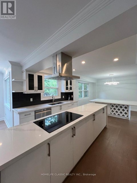A modern kitchen with white cabinets and a central island.