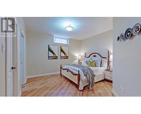 A bedroom with a bed, nightstands, and a mirror on the wall.