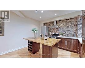 A kitchen with a wooden table and a stone wall backsplash.
