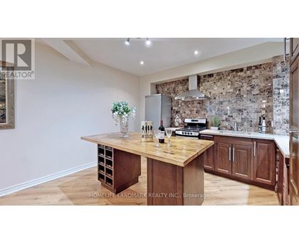 A kitchen with a wooden table and a stone wall backsplash.
