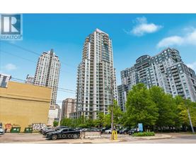 A cityscape with buildings and cars parked in the foreground.