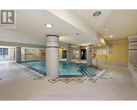 A large indoor swimming pool with a tiled floor and a glass wall.