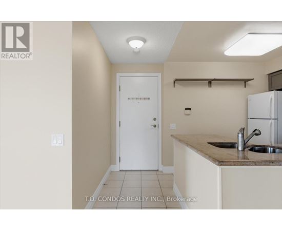 A kitchen area with a sink and a refrigerator.