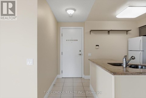 A kitchen area with a sink and a refrigerator.