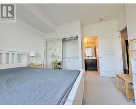 A bedroom with a large bed and a desk with a lamp.