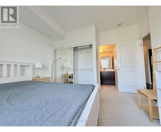 A bedroom with a large bed and a desk with a lamp.