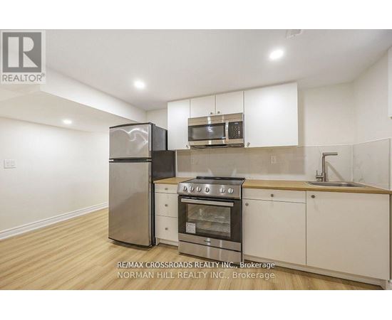 A kitchen with white cabinets and a stainless steel refrigerator.