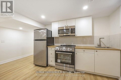 A kitchen with white cabinets and a stainless steel refrigerator.