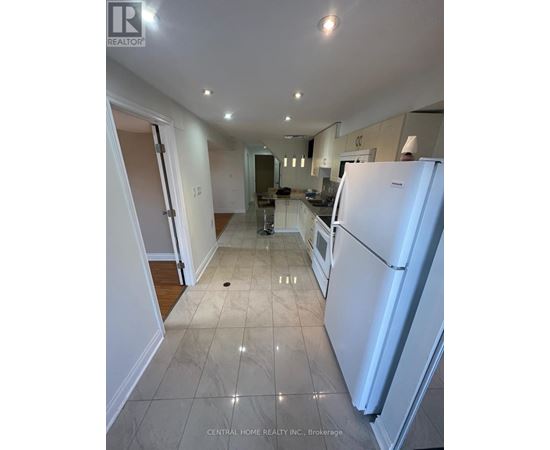 A white refrigerator is in the kitchen of a house.