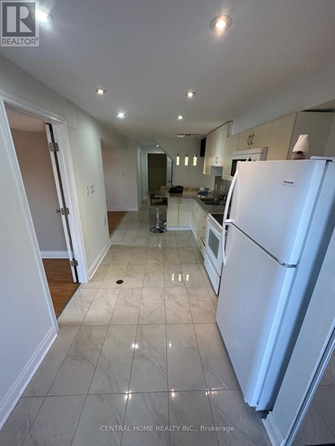 A white refrigerator is in the kitchen of a house.