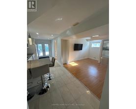 A spacious living room with a bar area and a television.