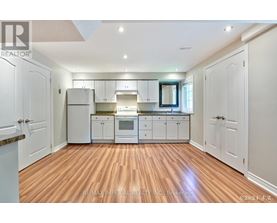 A kitchen with white cabinets and a wooden floor.