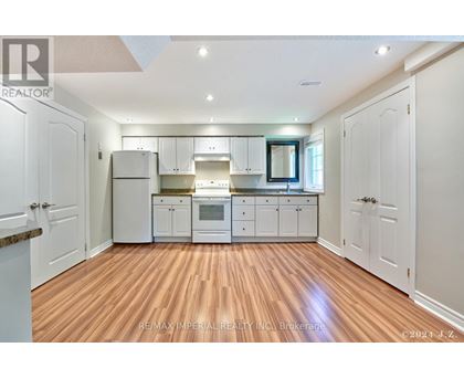 A kitchen with white cabinets and a wooden floor.