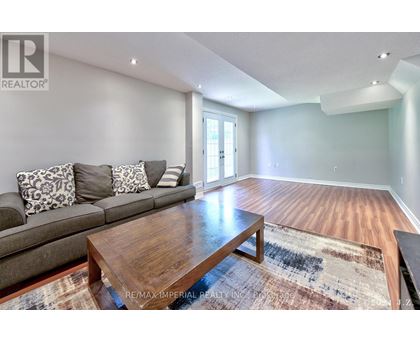 A living room with a grey couch and a wooden coffee table.