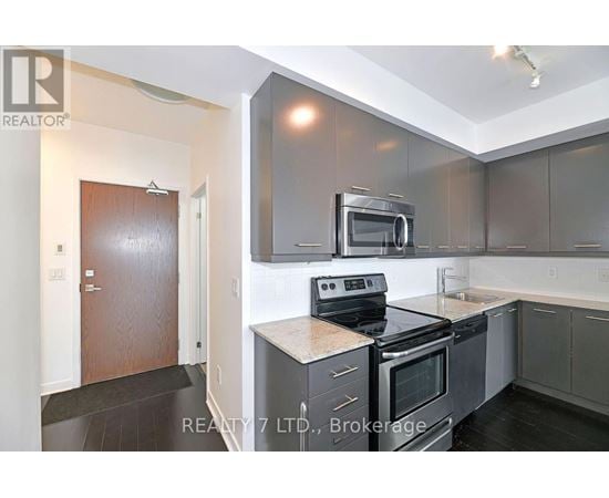A modern kitchen with a stove top oven and microwave above it.