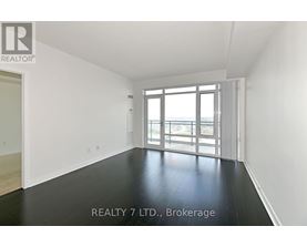 A spacious room with a sliding glass door leading to a balcony.