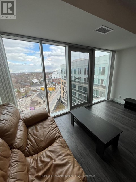 A brown leather sofa sits in a living room with a view of the city.