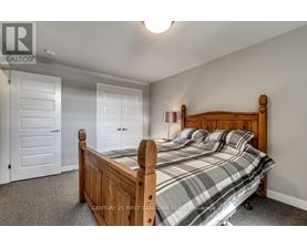 A bedroom with a bed, two doors, and a ceiling light.
