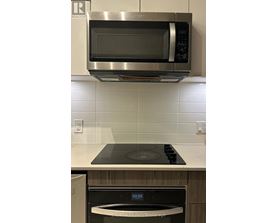 A stainless steel microwave oven mounted above a stove top.
