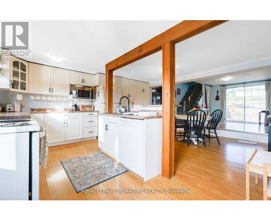 A kitchen with white cabinets and a wooden door frame.