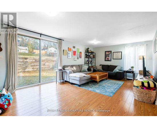 A living room with a white couch and a wooden floor.