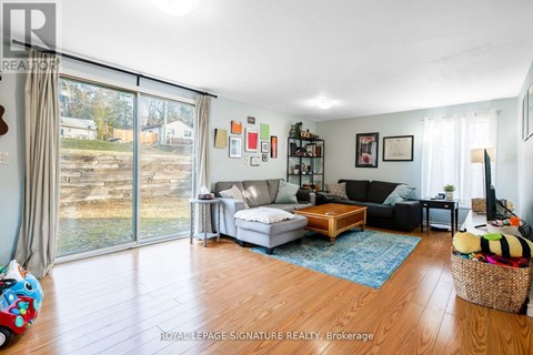 A living room with a white couch and a wooden floor.