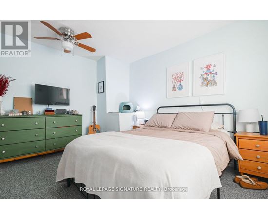 A bedroom with a bed, dresser, and ceiling fan.