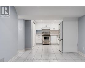 A white kitchen with a refrigerator, oven, and cabinets.