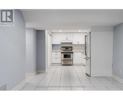 A white kitchen with a refrigerator, oven, and cabinets.