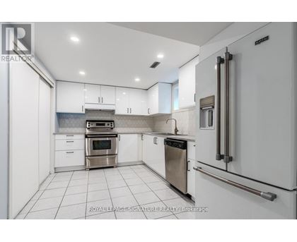 A white kitchen with a stainless steel oven and dishwasher.