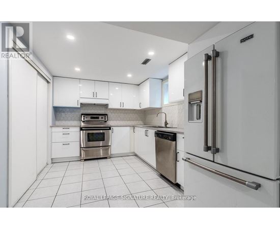 A white kitchen with a stainless steel oven and dishwasher.