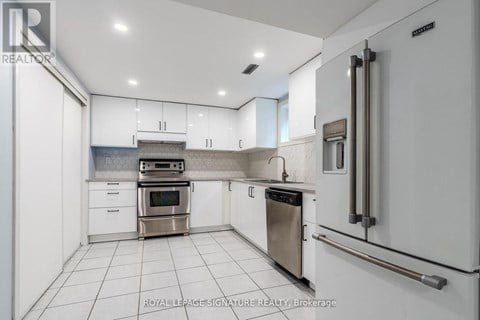 A white kitchen with a stainless steel oven and dishwasher.