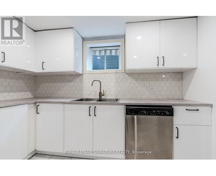 A kitchen with white cabinets and a stainless steel dishwasher.