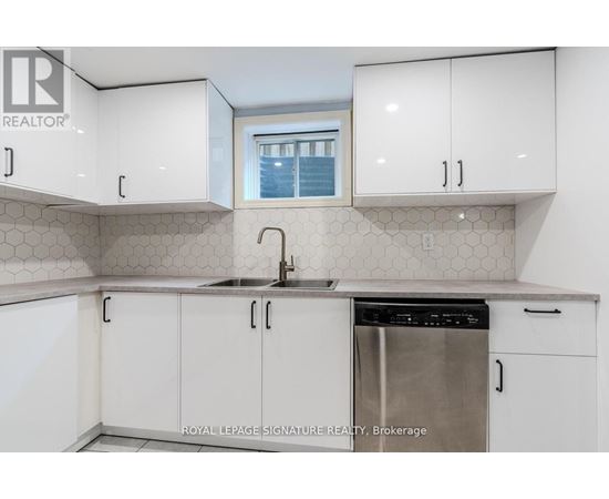A kitchen with white cabinets and a stainless steel dishwasher.