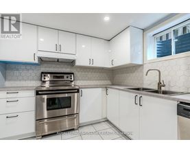 A kitchen with white cabinets and a stainless steel oven.