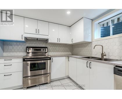A kitchen with white cabinets and a stainless steel oven.