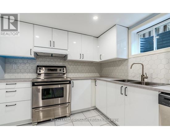 A kitchen with white cabinets and a stainless steel oven.