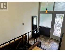 A room with a balcony and a door with a stained glass window.