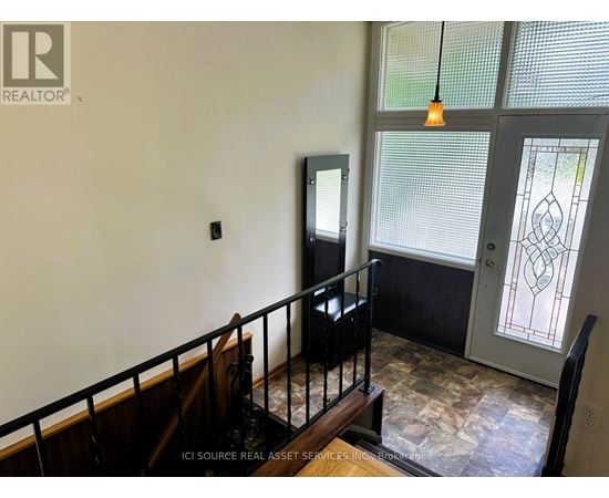 A room with a balcony and a door with a stained glass window.