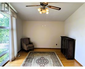 A room with a ceiling fan and a rug on the floor.