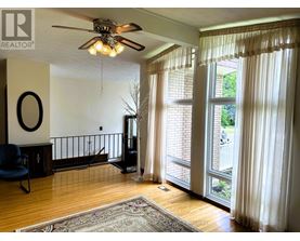 A living room with a ceiling fan and a blue chair.