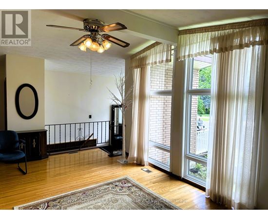 A living room with a ceiling fan and a blue chair.