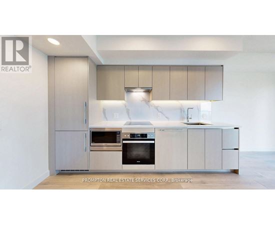 A modern kitchen with a stainless steel refrigerator and oven.
