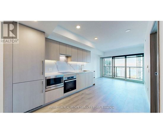 A modern kitchen with a large island and stainless steel appliances.