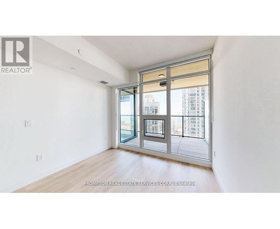A white room with a sliding glass door leading to a balcony.