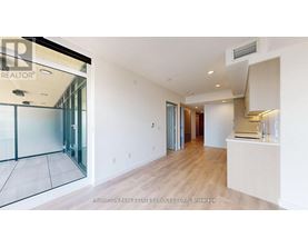 A spacious room with a glass door leading to a balcony.